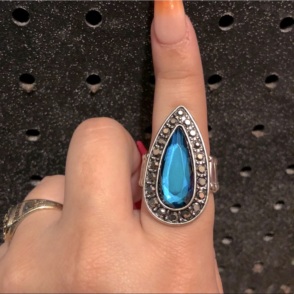 Silver ring with teardrop blue stone.